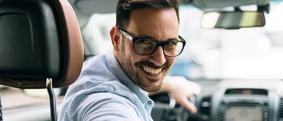 Smiling driver looking back from the driver seat.