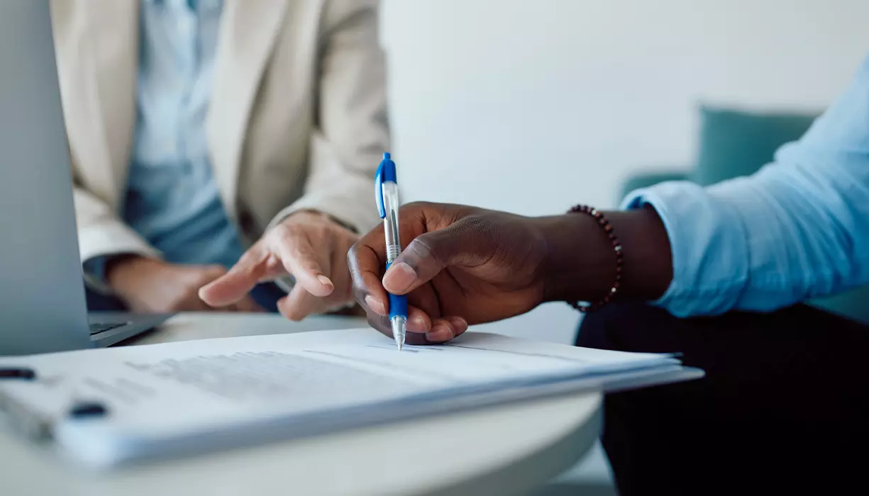 A zoomed in image of a hand signing a document.