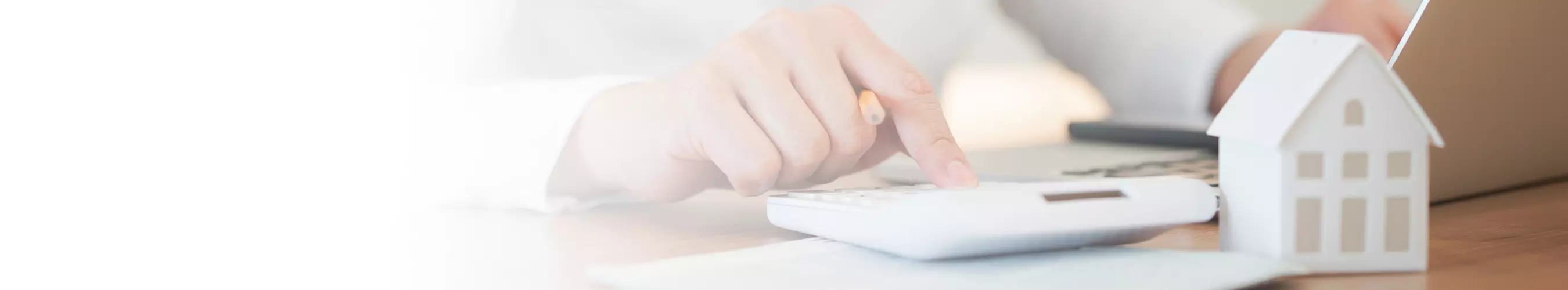 A closeup of a hand typing on a calculator.