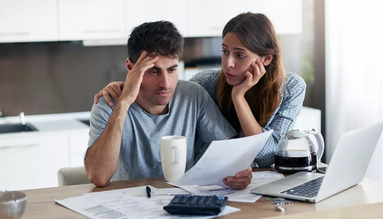 Two people looking at the document appearing concerned.