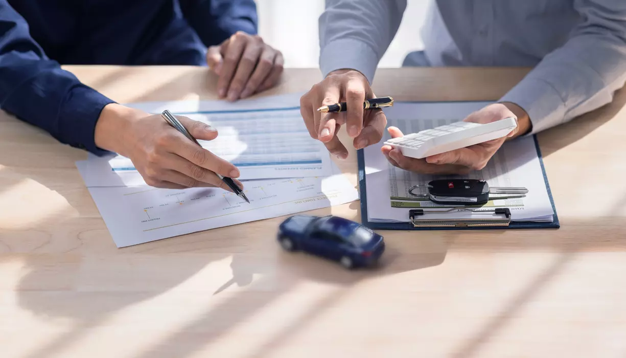 A picture of hands of two people pointing at something in a document.